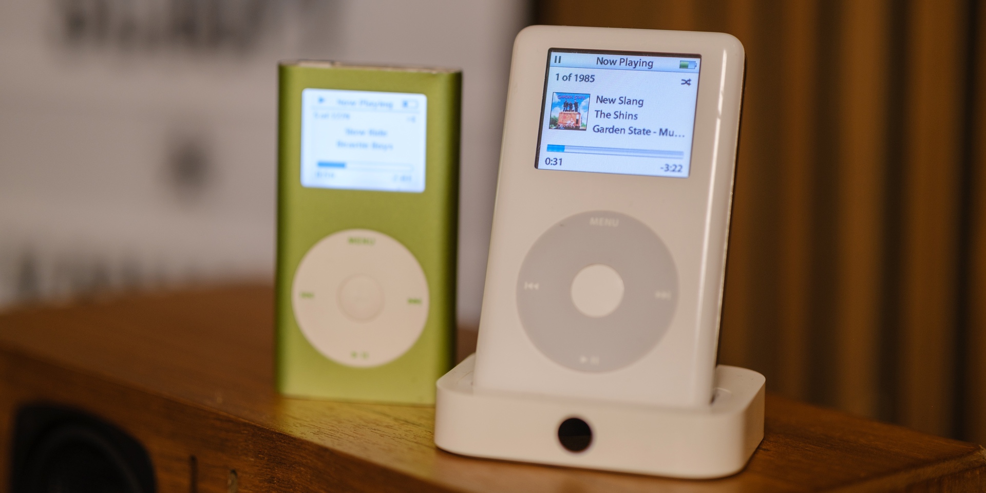 image showing an iPod 4th generation and a green iPod Mini. The iPod 4th generation shows the song "New Slang" by The Shins on the Garden State soundtrack.